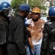 Silvanos Mudzvova being held by police during a protest performance
